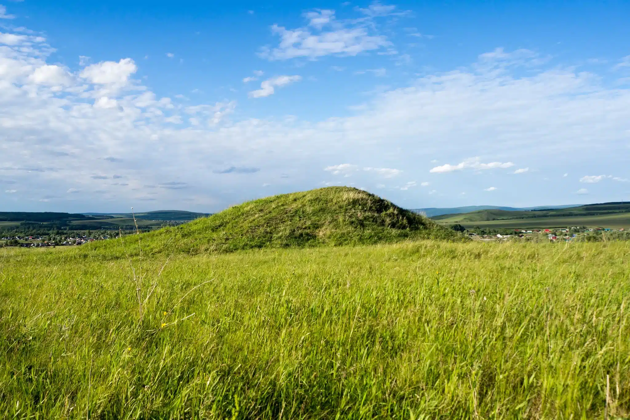 Green hill under blue sky, rural landscape for Green Burial Services in San Benito County, California