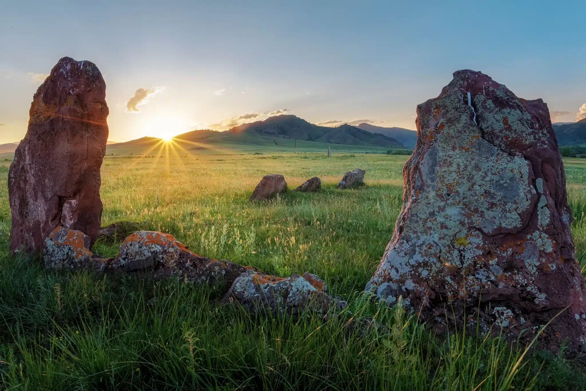 Sunset over grassy field with standing stones and hills for Green Burial Services in San Mateo County, California