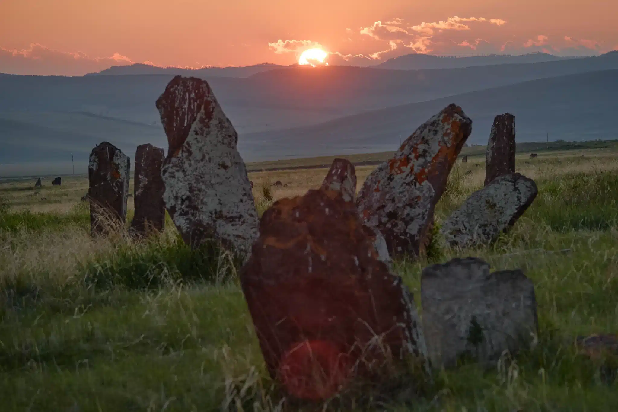 Sunset over ancient stone formations in grassy field for Green Burial Services in Sonoma County