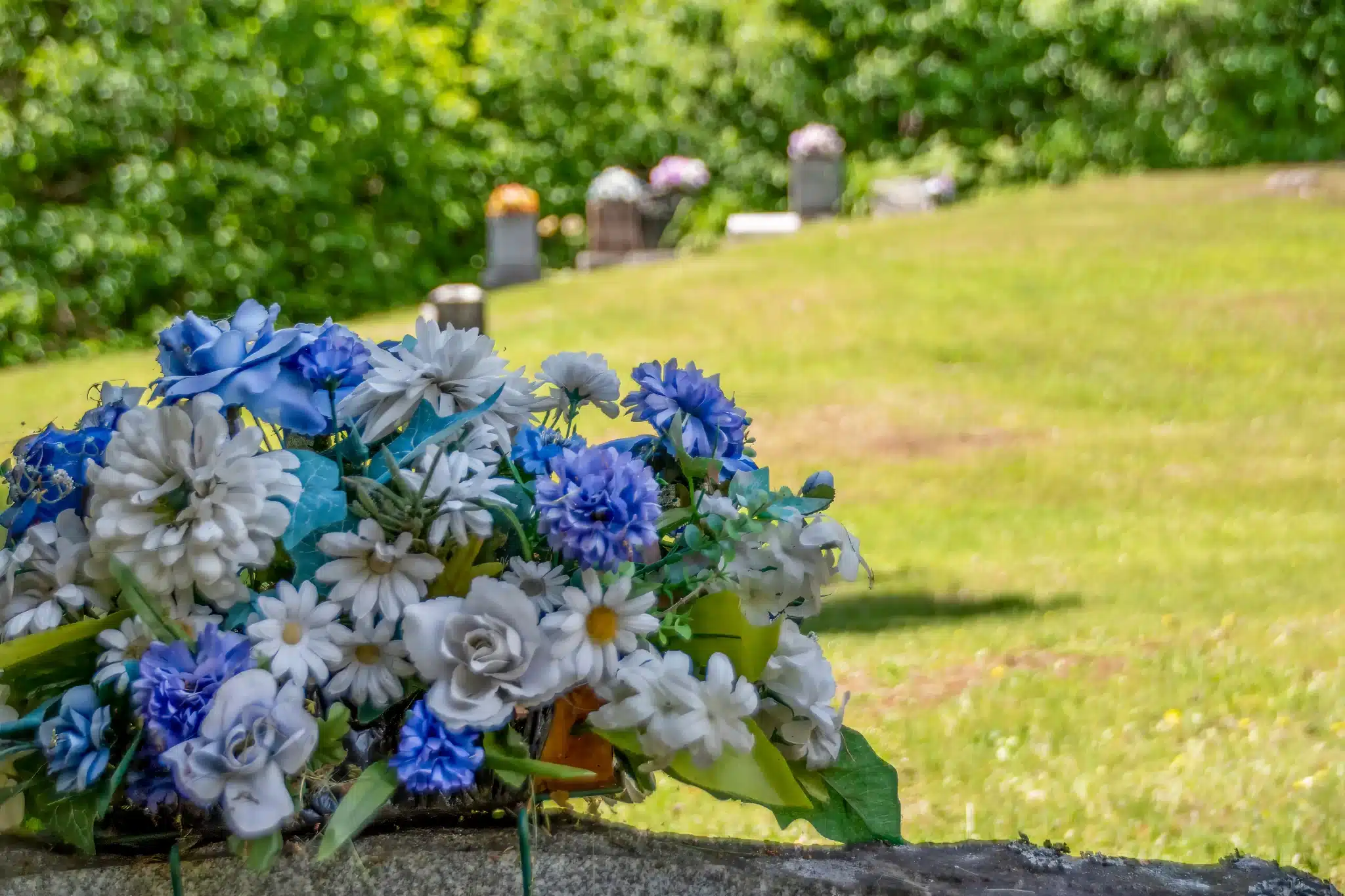 Colorful flowers on cemetery wall, blurred background for green burial services in corona del mar california